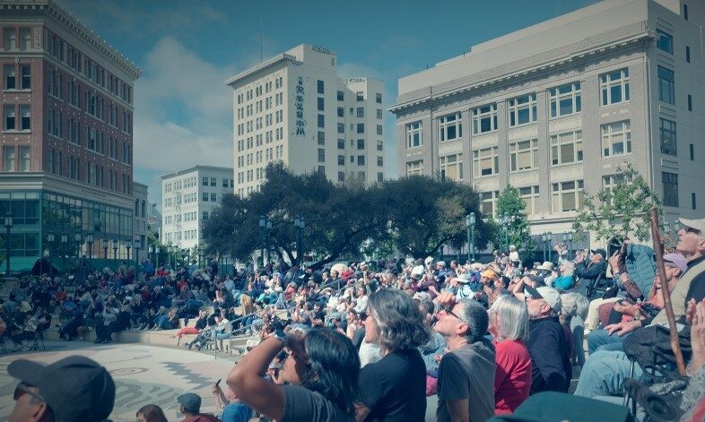 A group of people gathered and looking upward. 
