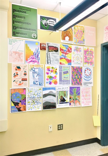 A number of artworks on a yellow wall. 