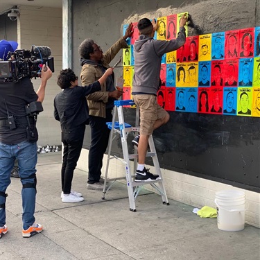 A group of people installing artwork. 