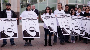 A group of people holding posters with a portrait of a man. 