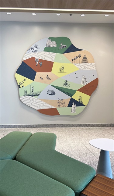 A large piece of art hanging on a grey wall. 