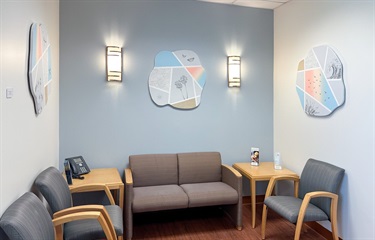 A small waiting room with three art pieces hanging on the wall. 