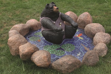 Sculpture of a bear surrounded by a mosaic. 