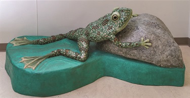 Sculpture of a frog perching on a rock. 