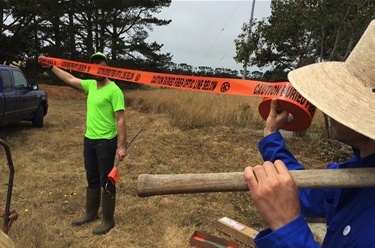 Two people holding caution tape.