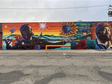 A mural on the wall with a series of portraits. 