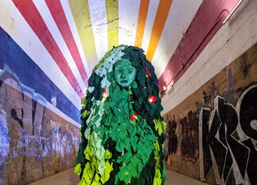 A green sculpture inside a tunnel. 