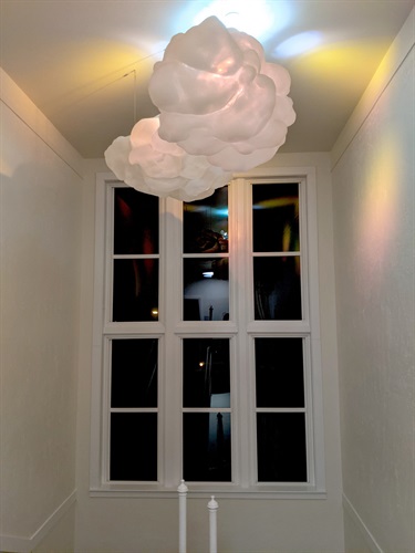 A white room with a cloud like light near the cieling.
