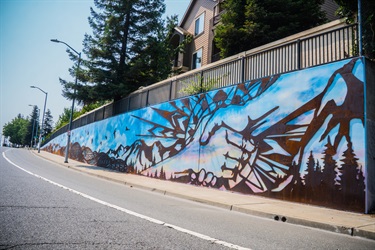 An art installation on a wall next to a road.