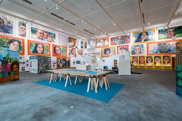 A gallery with many paintings on the wall. 