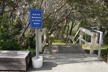 The entrance of a staircase surrounded by trees. 
