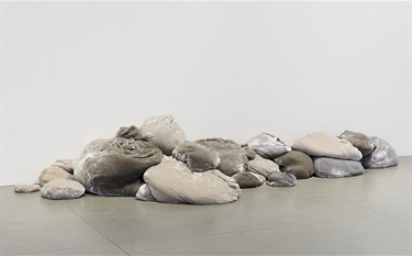 A pile of grey objects on a floor. 