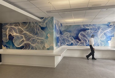 A blue and white mural on a white wall. 