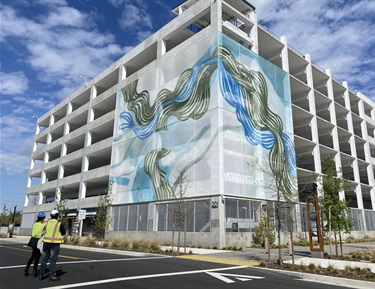 A large art installation on the facade of a parking garage.