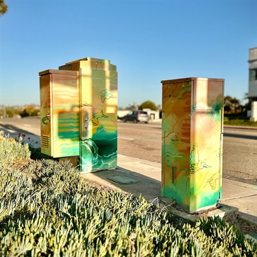 Utility boxes with artwork painted on the exterior.