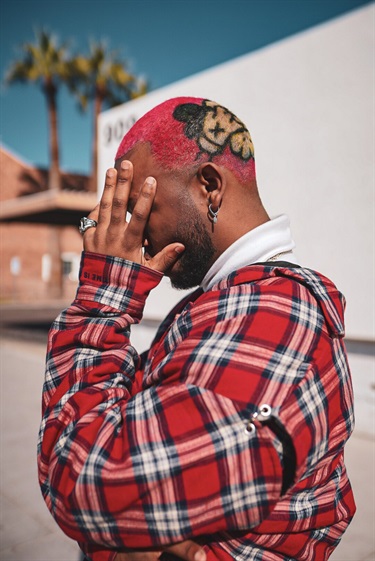 A person with red hair holding their face. 