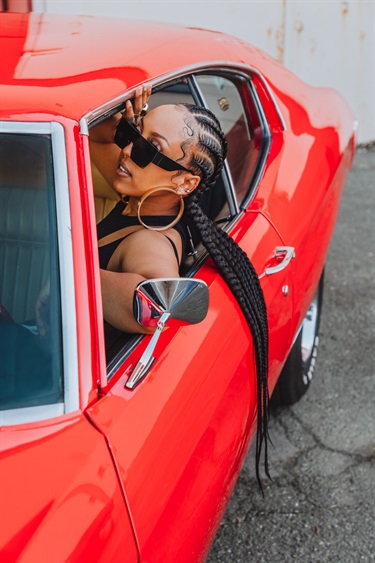A person sitting in a red car.