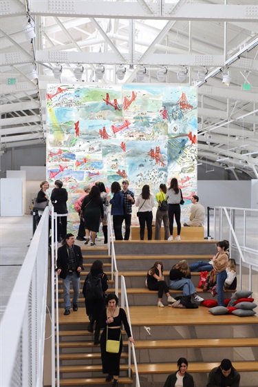 People looking at an art installation at the top of a staircase. of a staircase. 