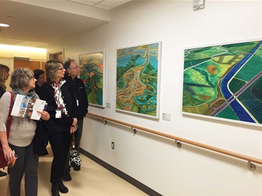 People looking at artwork on a wall. 