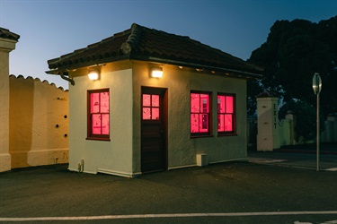 A small building with red light in the windows.