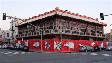 An art installation surrounding a building on the corner of the street.