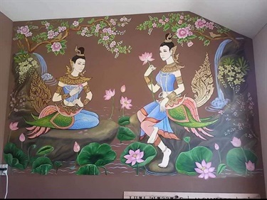 A painting of two people on a brown wall.