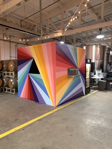 A painting on the outside of a cubical structure. 