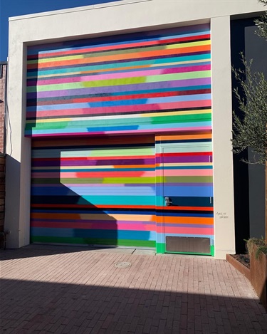 A colorful mural on the door of a garage. 