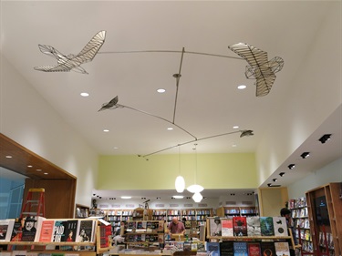 A sculpture on the ceiling of a bookstore.