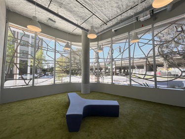 Inside a room with a green floor and blue bench.