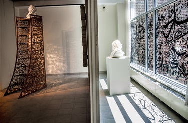 A gallery with artwork on the floor and window.