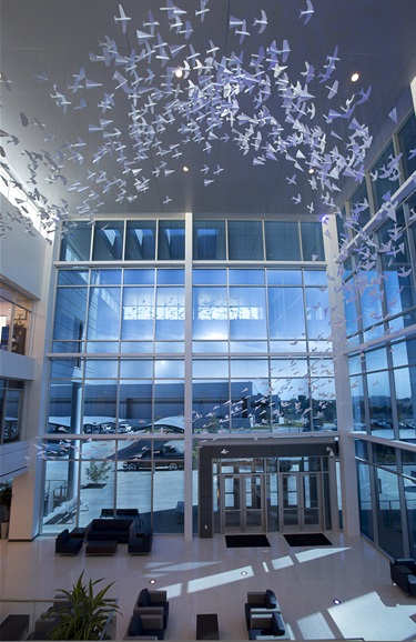 Sculptures suspended from the ceiling of a building lobby.