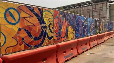 Colorful artwork attached to a construction fence. 