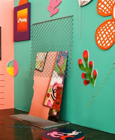 A colorful wall surrounded by artwork. 