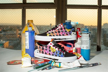 A pair of colorful sneakers and spray paint cans. 