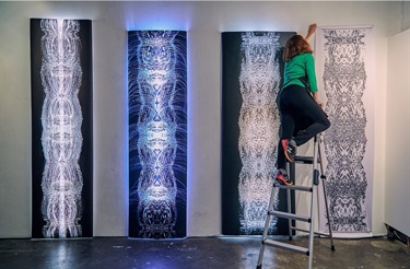 A person installing an art display.