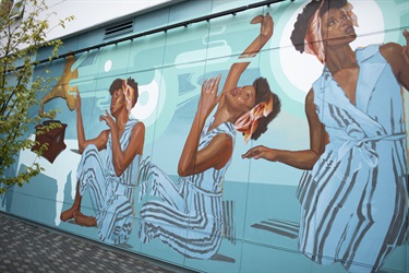 A large colorful mural on the side of a building. 