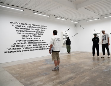 People viewing artwork displayed in a gallery.