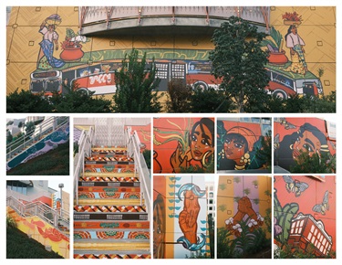 A mural painted on the side of a building and a staircase. 