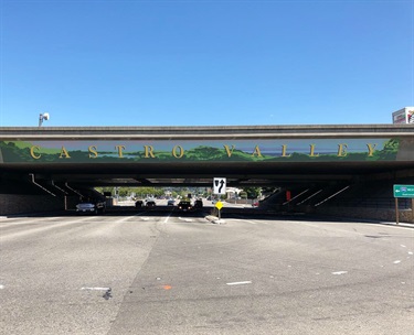 A mural painted on the side of a street overpass. 