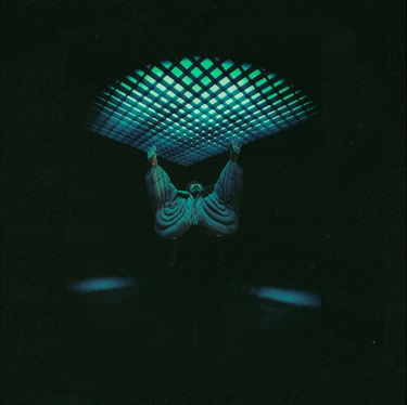 A photograph of a person holding up their arms. 