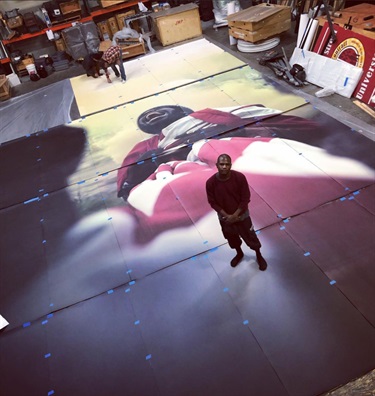 A person standing on a large photograph print. 