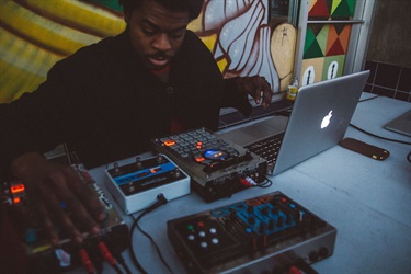 A person working on a laptop and mixing tables.
