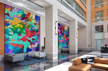 Two large artworks on the wall of a lobby. 