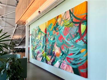 A large painting hanging on a white wall. 