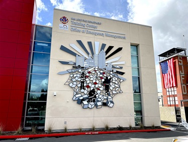 A laser cut art piece on the wall of a building. 