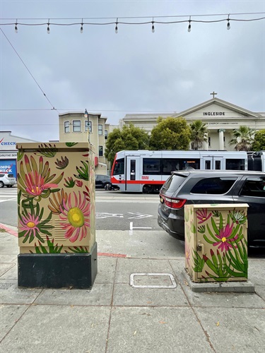 Painted utility boxes on the sidewalk.