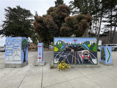 Painted utility boxes on the sidewalk. 