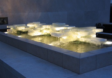 An abstract glass sculpture in a fountain. 