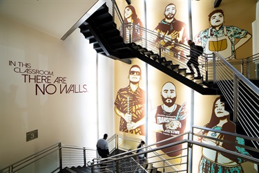 A mural painted on a wall near a staircase.